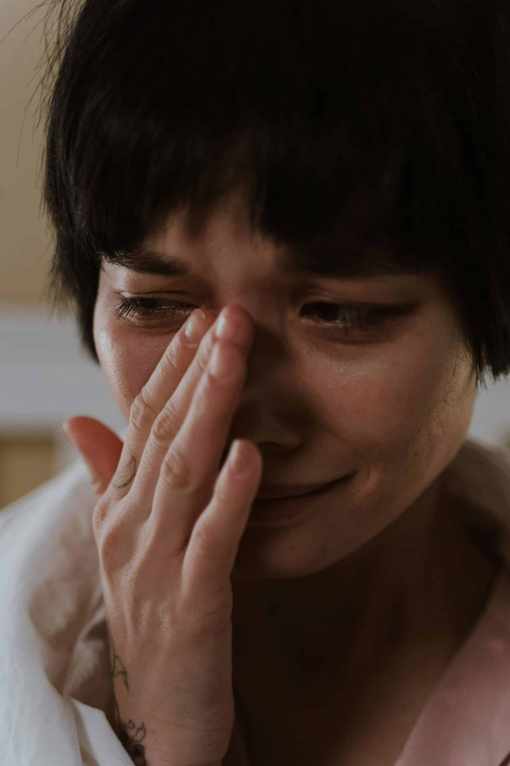 Woman with short dark hair crying