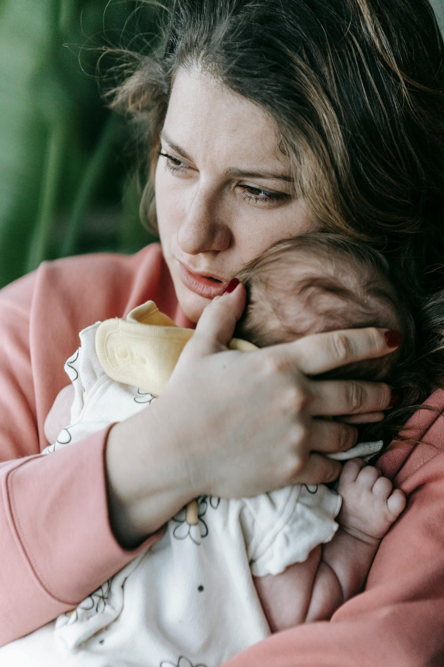 Mother holding baby looking distressed